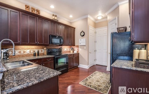 A kitchen with dark wood cabinets and granite countertops.