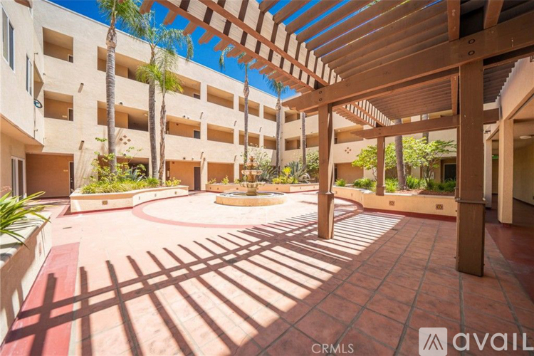 A sunny day at the outdoor patio of a building with a fountain in the center.
