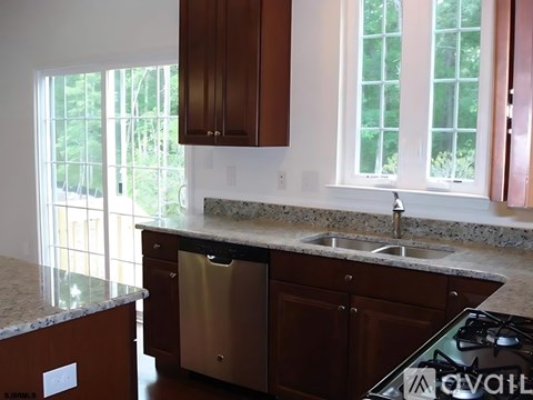 A kitchen with brown cabinets and a granite countertop.