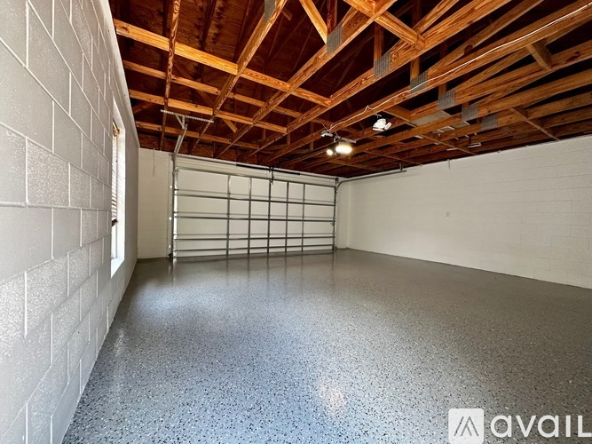 A spacious room with a concrete floor and a wooden ceiling.