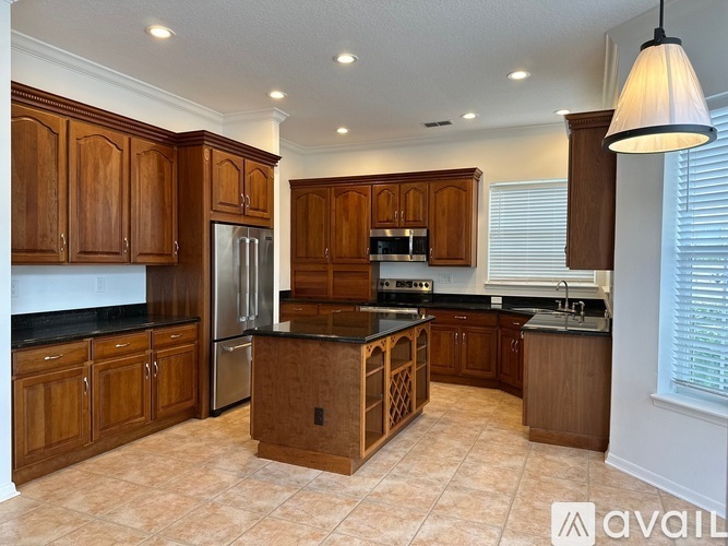 A kitchen with wooden cabinets and a black countertop.