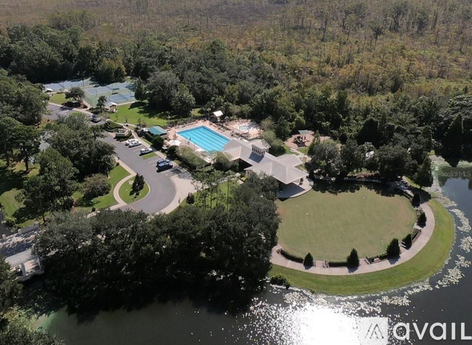 An aerial view of a resort with a swimming pool and a winding road.
