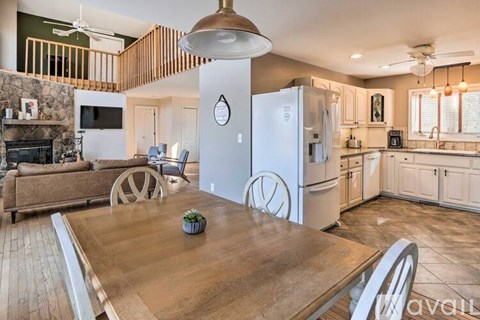 A kitchen with a wooden table and a refrigerator with a clock on it.