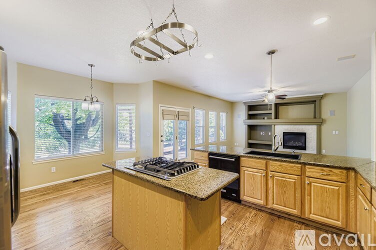 A kitchen with wooden cabinets and a granite countertop.