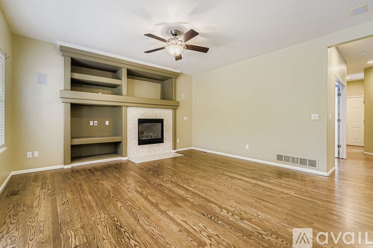 A living room with a fireplace and wooden floors.