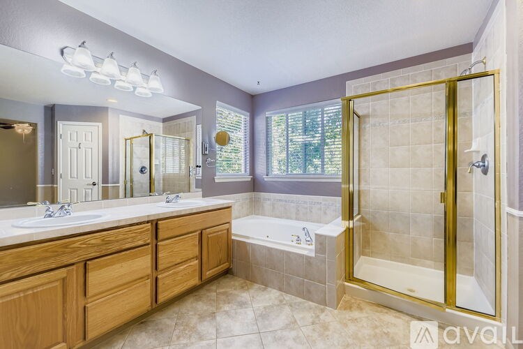A bathroom with a tub, sink, and mirror.