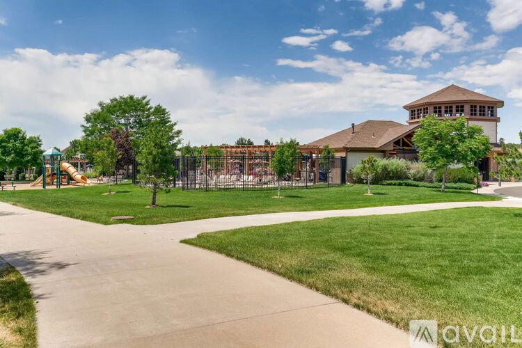A playground with a slide and a building in the background.