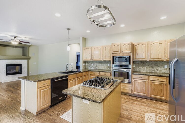 A kitchen with wooden cabinets and a granite countertop.