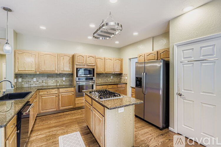 A kitchen with wooden cabinets and a granite countertop.