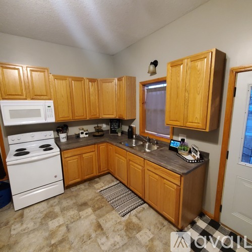 A kitchen with wooden cabinets and a white stove.