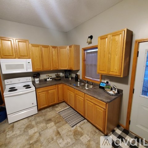A kitchen with wooden cabinets and a white stove.