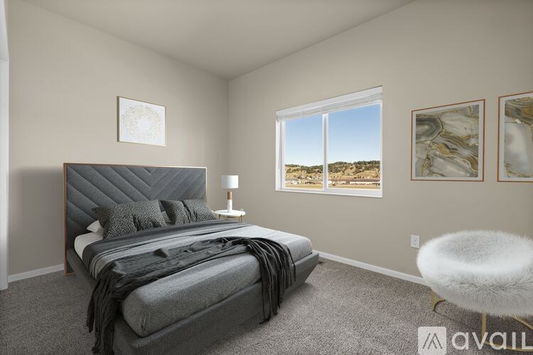 A bedroom with a large bed and a window overlooking a desert landscape.