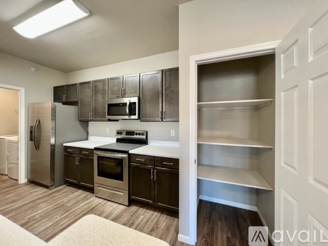 A kitchen with stainless steel appliances and wooden floors.