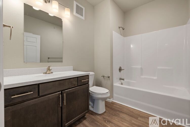 A bathroom with a white tub, sink, and toilet.
