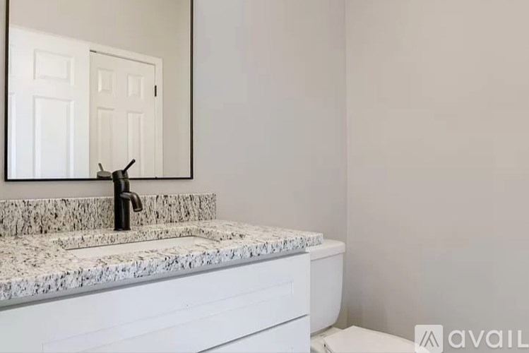 A bathroom with a marble countertop and a white sink.