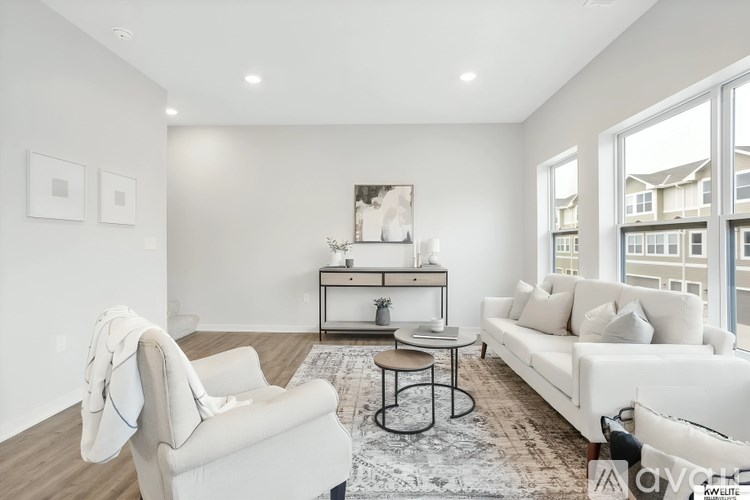 A living room with a white couch, a chair, and a coffee table.