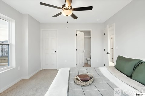 A living room with a white couch and a ceiling fan.