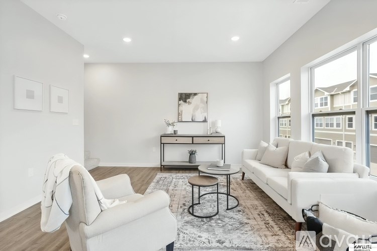 A living room with a white couch, a white chair, and a coffee table.