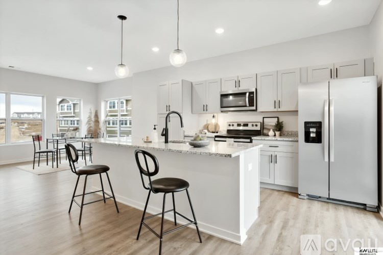 A modern kitchen with white cabinets and a large island.