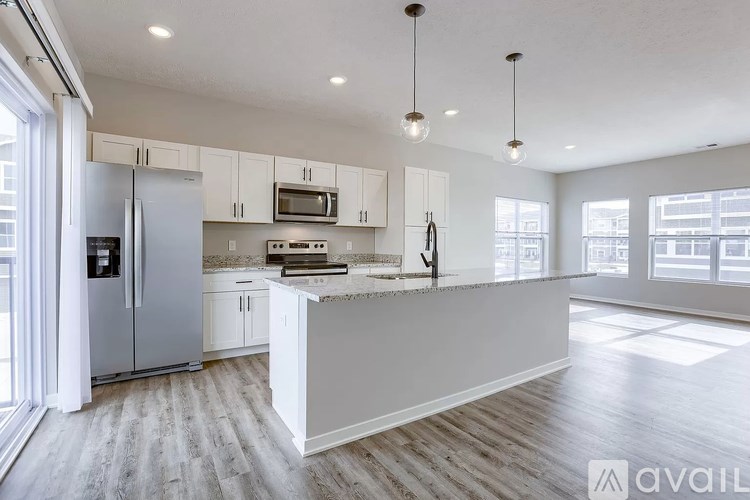 A kitchen with white cabinets and a marble countertop.