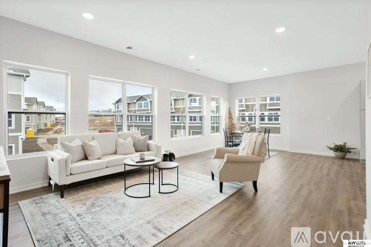 A living room with a white sofa, a coffee table, and a chair.