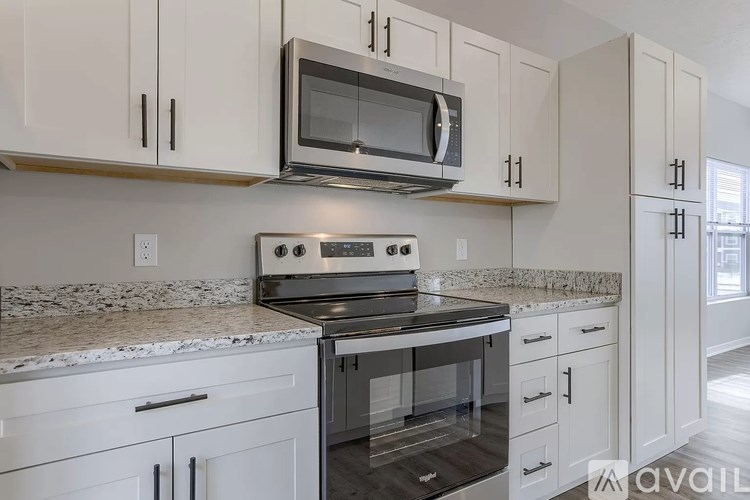 A kitchen with white cabinets and a granite countertop.