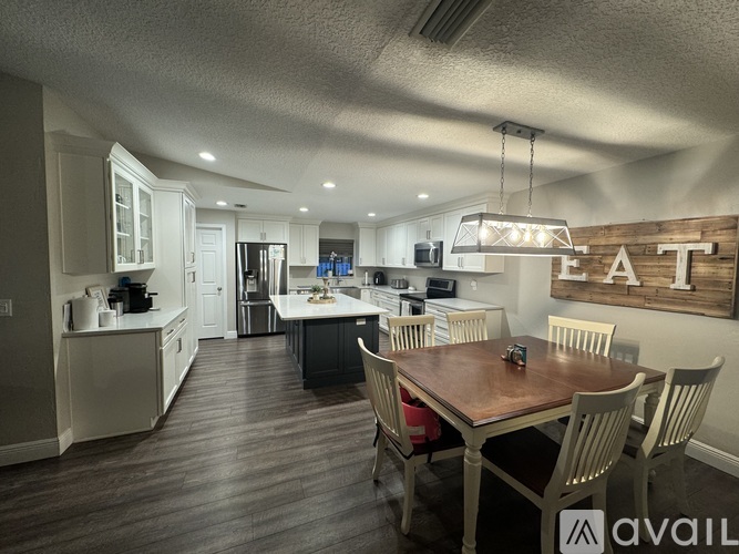 A kitchen with a dining table and chairs.