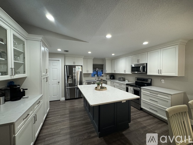 A modern kitchen with white cabinets and a central island.
