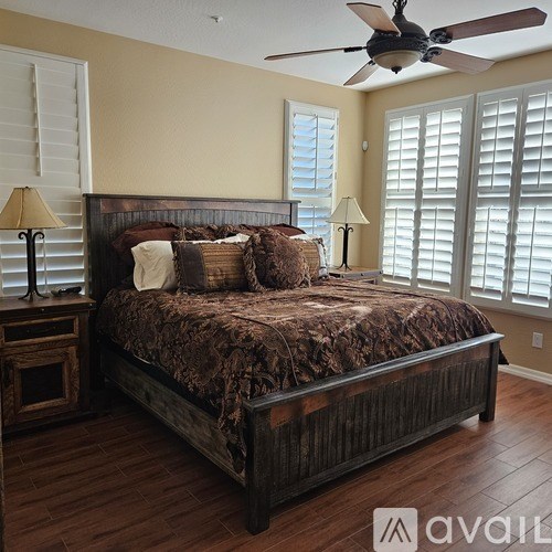 A bedroom with a large bed and a ceiling fan.