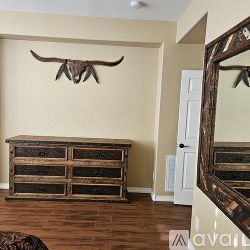 A room with a wooden dresser and a mirror.