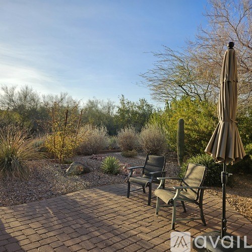A patio with a table and chairs and an umbrella.