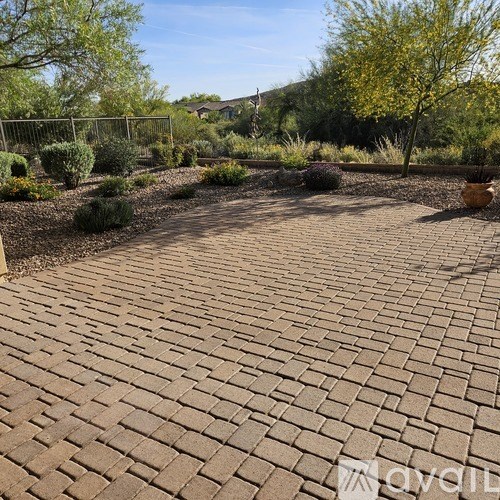 A brick patio surrounded by a garden.