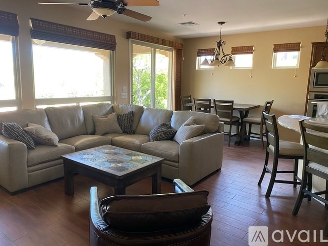 A living room with a couch, chairs, and a coffee table.