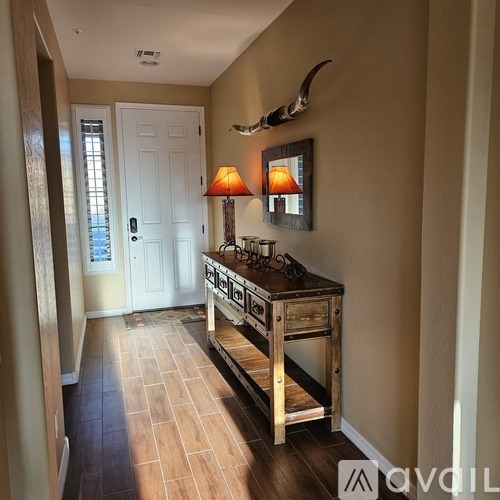 A hallway with a wooden cabinet and a lamp on top.