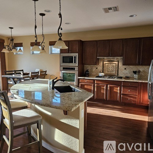 A kitchen with a granite countertop and wooden cabinets.