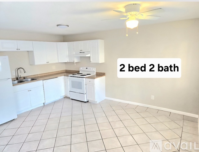 A kitchen with white appliances and cabinets.