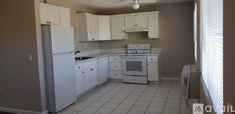 A kitchen with white appliances and cabinets.