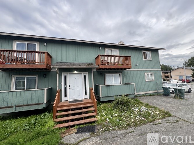 A building with a balcony and a small garden in front.