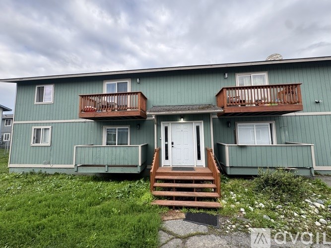 A room with a white wall and wooden floor is shown.