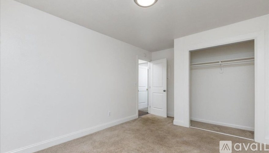 A room with a carpeted floor and a white door.