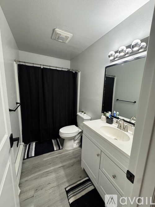 A white room with a carpeted floor and a doorway leading to another room.