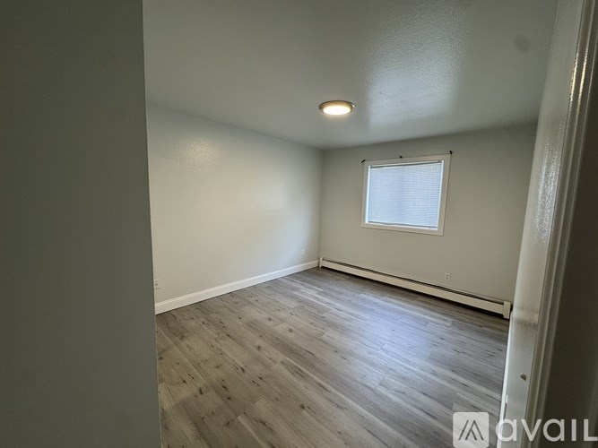 A room with a window and a carpeted floor.