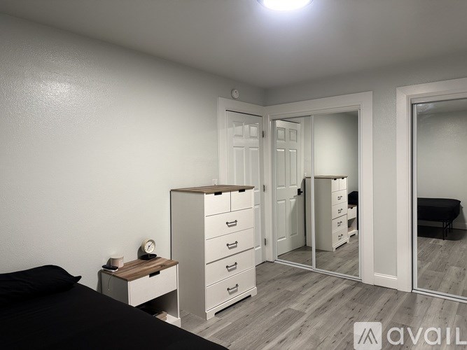 A bedroom with a bed, nightstand, and wardrobe.