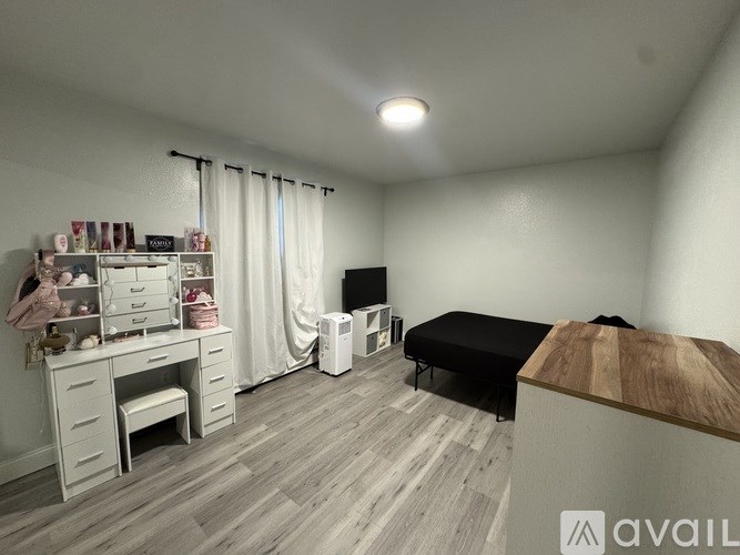 A room with a desk, chair, and a bed.