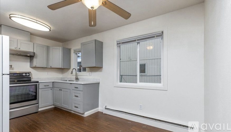 A kitchen with a stove top oven and a fan.
