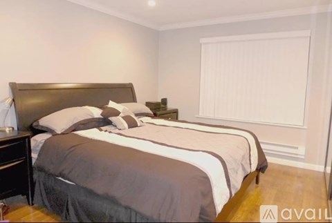 A bedroom with a large bed and a wooden headboard.