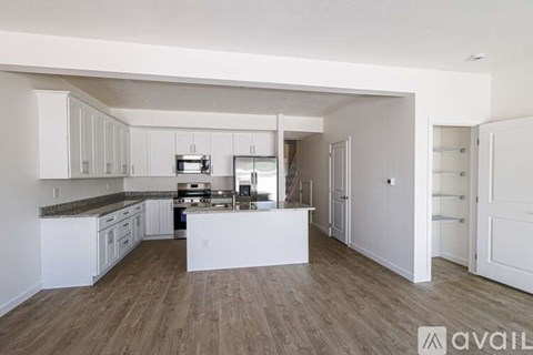 A kitchen with white cabinets and a wooden floor.