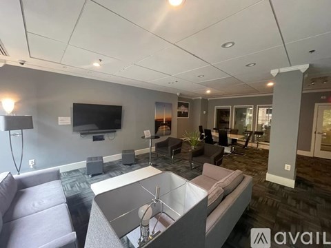 A modern living room with a grey sofa and a television on the wall.