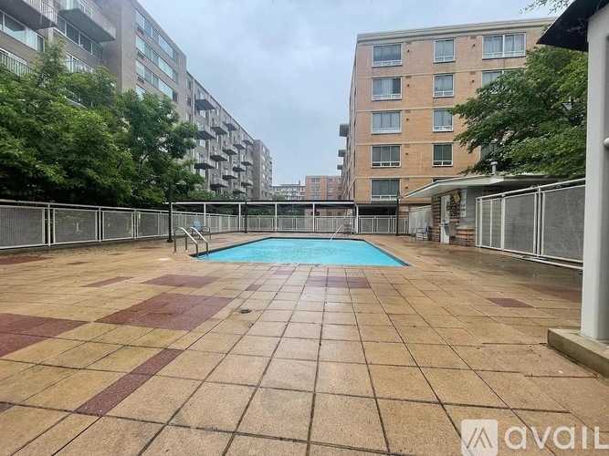 A pool surrounded by a tiled patio in a residential area.
