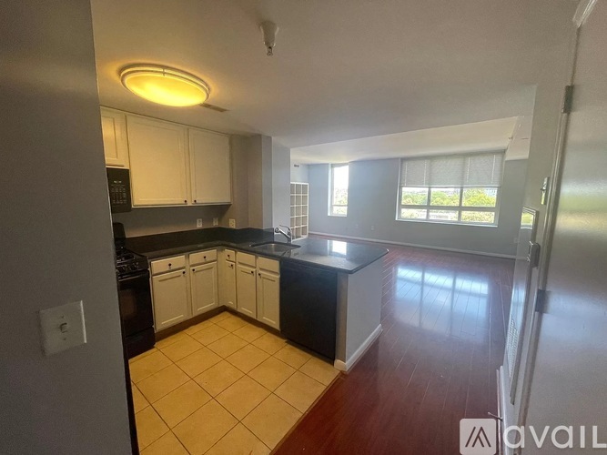 A kitchen with white cabinets and a black dishwasher.